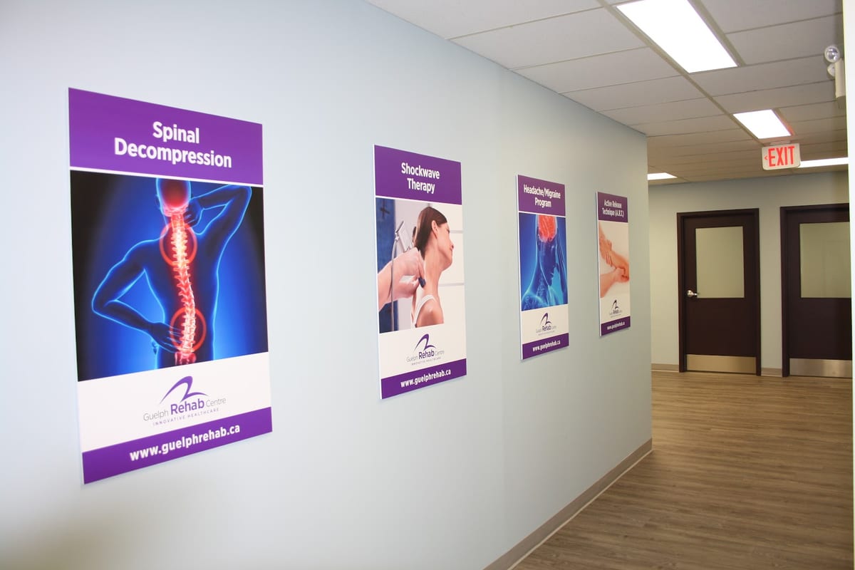 The clinic corridor at Guelph Rehab Centre, with the clinic's own spinal decompression and shockwave therapy posters
